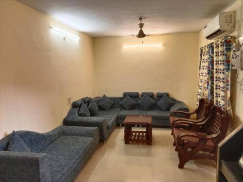 a living room with a blue couch and chairs at MANNAT VILLA 2bhk in Daman