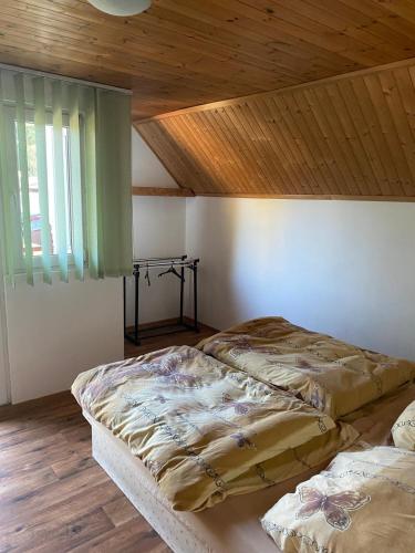 two beds in a room with a wooden ceiling at Penzion U Hájčusů in Karlovy Vary