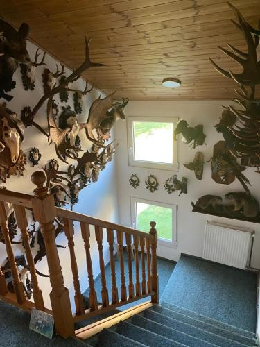 a room with a staircase withanimal skulls on the wall at Penzion U Hájčusů in Karlovy Vary