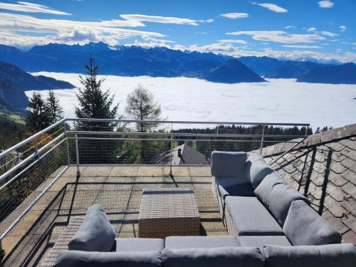 a balcony with couches and a view of the mountains at Hotel Bergsonne Rigi in Rigi Kaltbad