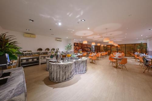 a restaurant with tables and chairs in a room at SureStay By Best Western Iconic Suvarnabhumi in Samut Prakan