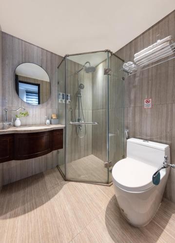 a bathroom with a shower and a toilet and a sink at Hanoi Calista Hotel & Spa in Hanoi