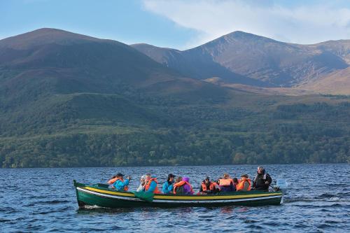 a group of people in a boat on a lake at Gleneagle River Apartments in Killarney