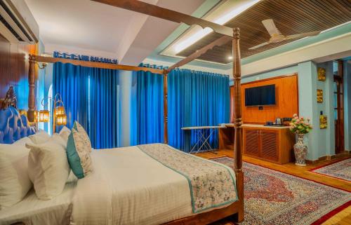 a bedroom with a canopy bed with blue curtains at The Kurki Heritage in Jaipur