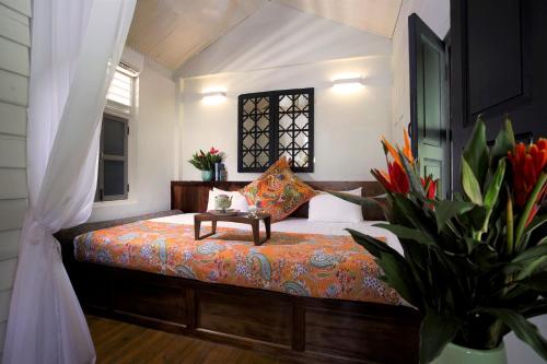a bedroom with a bed with a table on it at Muntri Mews in George Town