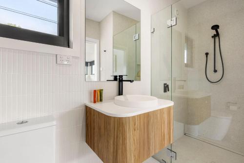 a bathroom with a sink and a shower at Azure Studio - Ocean Glimpses - 3 Mins Walk to Beach in Callala Beach