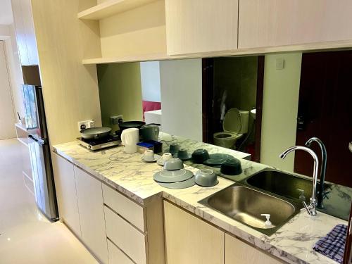 a kitchen with a sink and a counter top at ONE BEDROOM APARTMENT POLLUX MEISTERSTADT BATAM centre in Bagam