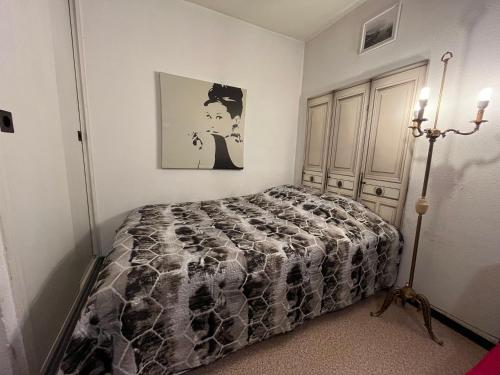 une chambre avec un lit et un tableau au mur dans l'établissement Logement entier à 50 métre de la Parc de la Tête d'Or, à Villeurbanne