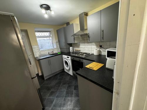 a kitchen with gray cabinets and a black counter top at Double bed BW4 Accrington Burnley in Accrington
