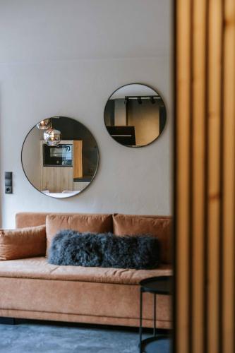 salon z kanapą i dwoma lustrami w obiekcie House 55 w Solden