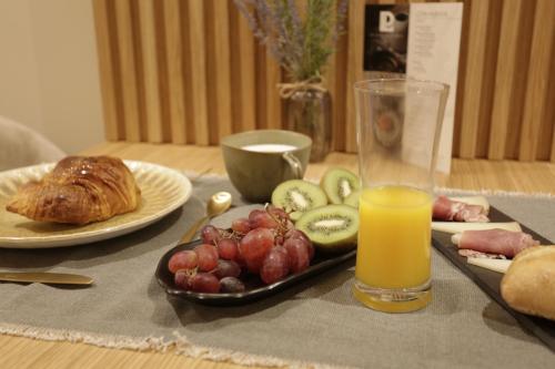 a table with a tray of fruit and a glass of orange juice at Hotel Puerto de Luarca in Luarca