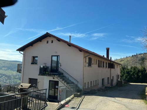 un bâtiment blanc avec un escalier sur son côté dans l'établissement Les Pâturages, à La Bresse