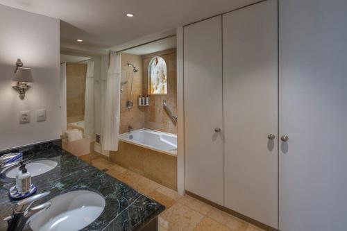 a bathroom with a sink and a tub at Presidente InterContinental Puebla by IHG in Puebla