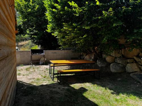 a picnic table and a bench next to a tree at Chalet de montagne Sant Feliu Feliu à Dorres in Dorres