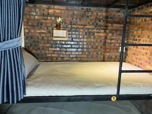 a room with a bed in a brick wall at Venn Hostel in Vientiane