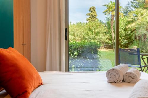 a bedroom with a bed and a large window at Les 15 Pins & La Mer -Your green getaway near sea & beach in Antibes