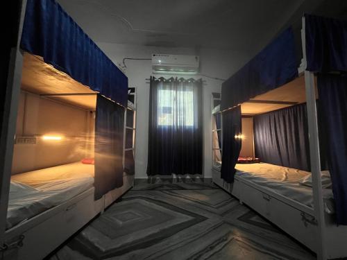 two bunk beds in a room with a window at The GreenView HomeStay in Rishīkesh