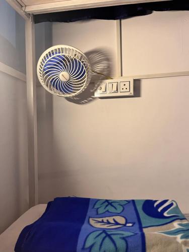 a fan hanging from a wall above a bed at The GreenView HomeStay in Rishīkesh