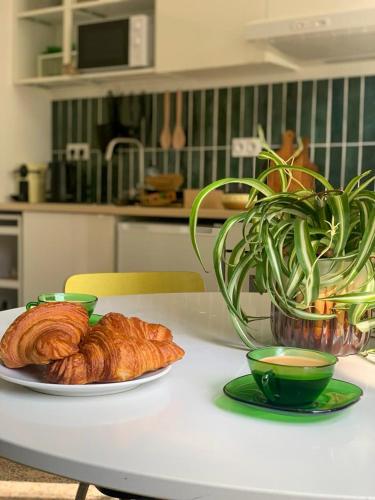 une table blanche avec un plateau de croissants et une plante dans l'établissement Arceaux, à Montpellier