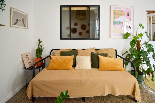 une chambre avec un lit avec des oreillers orange et verts dans l'établissement Arceaux, à Montpellier