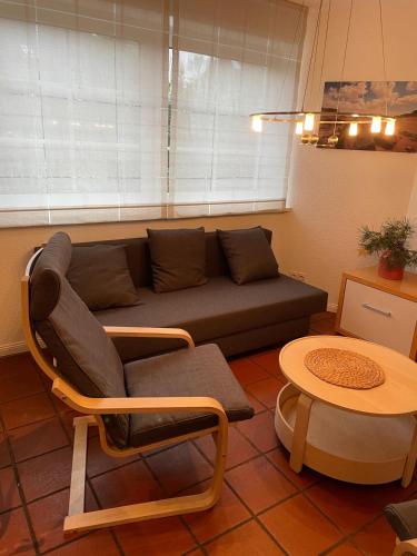 a living room with a couch and a table at Twenge Retreat - Haus Nähe Stadt und Flughafen mit Garten, 3 Zimmer, TV, Küche, Bad und Netflix in Altenhorst