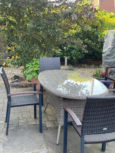 a patio table with two chairs and a table with a glass top at Twenge Retreat - Haus Nähe Stadt und Flughafen mit Garten, 3 Zimmer, TV, Küche, Bad und Netflix in Altenhorst
