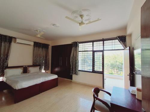 a bedroom with a bed and a table and a window at NICE Stay & Care in Noida