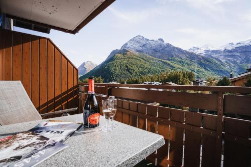a bottle of wine sitting on a table with a glass at Hotel Etoile & Alpenperle Residences in Saas-Fee