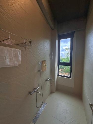 a bathroom with a shower and a window at Lin's Forest in Hengchun
