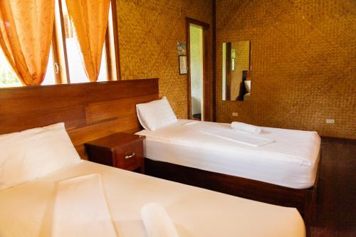 a hotel room with two beds and a mirror at Marianne Port Barton in San Vicente