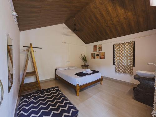 a bedroom with a bed and a ladder in a room at Sunset Cafe Beach Stay in Gokarna