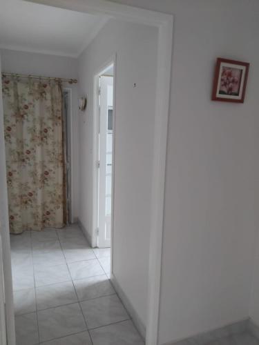 un couloir aux murs blancs et une chambre avec un miroir dans l'établissement Douric, à Brest