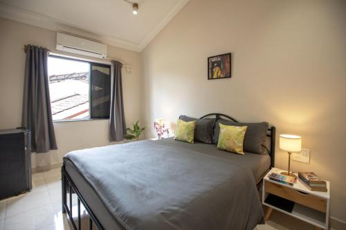 a bedroom with a large bed and a window at NomadGao Vila Nova - Comfort, Great Views, Fast WiFi & Interesting People in Anjuna