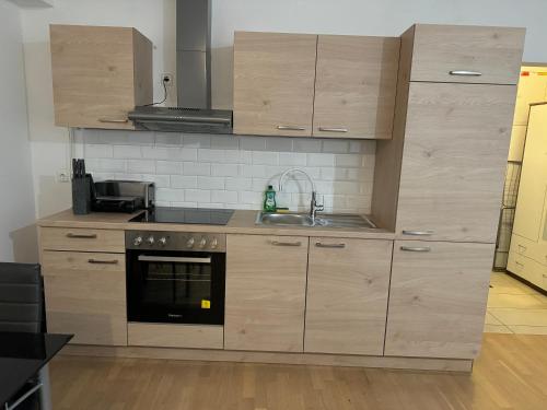 a kitchen with wooden cabinets and a sink at Apartment Na skali in Kranj