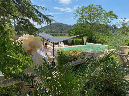 a garden with a swimming pool in the background at Mes nuits au château au domaine du pressoir in Pierrefeu-du-Var