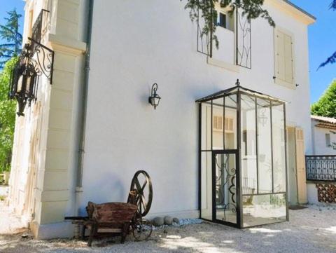 a white building with a door and a wheel next to it at Mes nuits au château au domaine du pressoir in Pierrefeu-du-Var