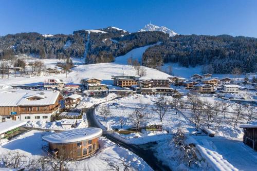 a town covered in snow with a river and mountains at Hotel Penzinghof in Oberndorf in Tirol