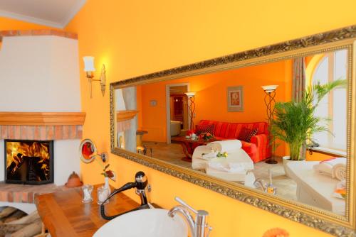 a mirror in a living room with a fireplace at Hotel BEI SCHUMANN in Kirschau