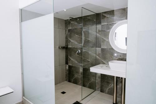 a bathroom with a shower and a sink at Huis Marais Oubaai Golf Estate in Herolds Bay