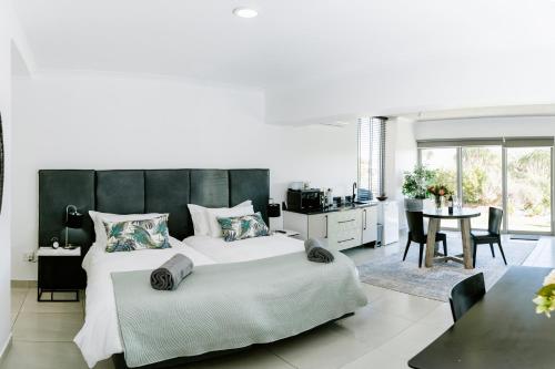 a bedroom with a large bed and a dining room at Huis Marais Oubaai Golf Estate in Herolds Bay