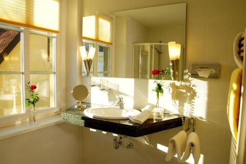 a bathroom with a sink and a mirror at Hotel BEI SCHUMANN in Kirschau