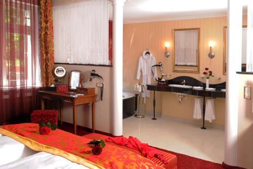 a bedroom with a bathroom with a sink and a tub at Hotel BEI SCHUMANN in Kirschau