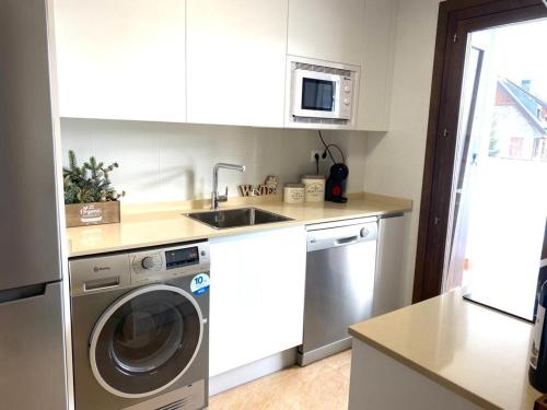 a kitchen with a washing machine and a sink at Chalet pareado para familias in Formigal