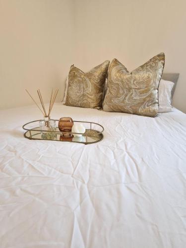 a tray with candles and pillows on a bed at Apartment Near Wembley Stadium Heathrow London Barnet Luton Airport Hendon Middlesex University - FREE Parking & WiFi - Work Contractors & Tourists Welcome in Edgware