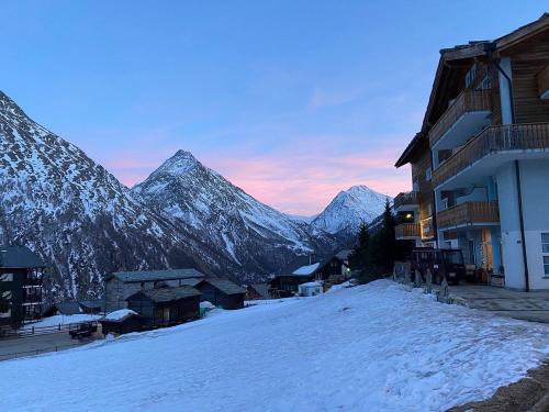 a snow covered mountain range in the distance with a building at Hotel Etoile & Alpenperle Residences in Saas-Fee