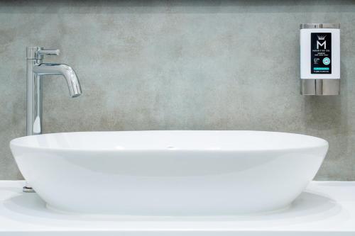 a white sink in a bathroom with a faucet at HOTEL Am Spichernplatz in Düsseldorf
