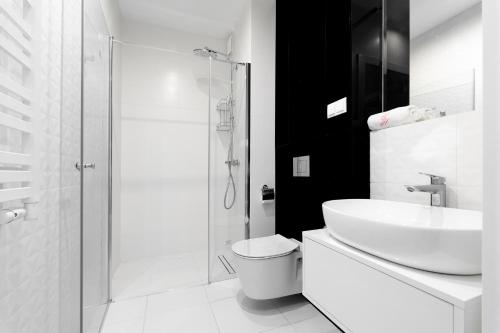 a bathroom with a sink and a toilet and a shower at Your Holidays Waves in Międzyzdroje