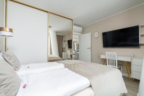 a bedroom with a white bed and a large mirror at Your Holidays Waves in Międzyzdroje
