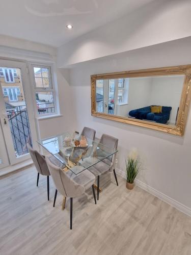 a dining room with a glass table and chairs at Apartment Near Wembley Stadium Heathrow London Barnet Luton Airport Hendon Middlesex University - FREE Parking & WiFi - Work Contractors & Tourists Welcome in Edgware