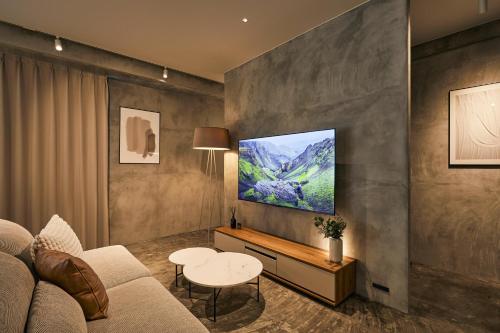 a living room with a couch and a tv on a wall at Spacious Tokyo Base near Tamachi station Hotel Ten Tamachi in Tokyo